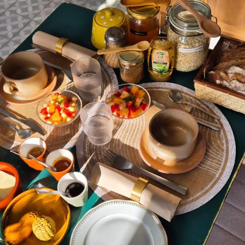 een tafel met borden en kommen met eten erop bij Chambre d'hôte à "Tandem House" in Saint-Rambert-sur-Loire