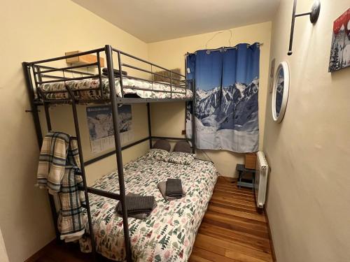 ein kleines Schlafzimmer mit einem Etagenbett und einem Etagenbett in der Unterkunft Charme et confort au pied des pistes in Naut Aran