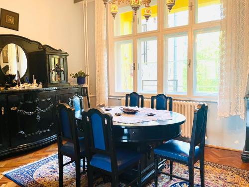 una sala da pranzo con tavolo, sedie e uno specchio di Central with Parking 3 Bedroom Apartment a Novi Sad