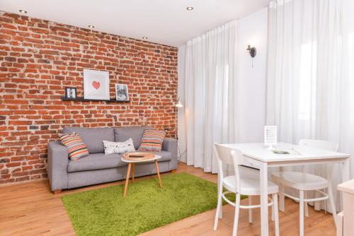 a living room with a couch and a brick wall at Antim Boutique Apartments in Sofia
