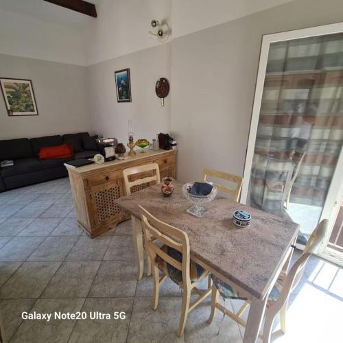 un salon avec une table, des chaises et un canapé dans l'établissement La Maddalena T2 47m2 50 metre de la plage, à Borgo