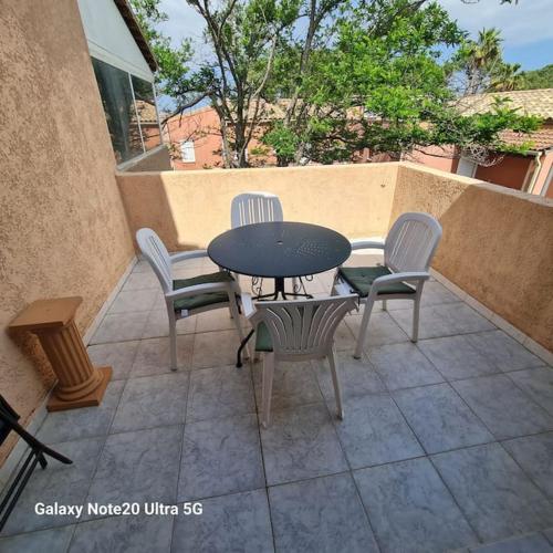 un patio avec une table et des chaises sur un patio dans l'établissement La Maddalena T2 47m2 50 metre de la plage, à Borgo