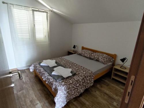 a small bedroom with a bed and a window at Pocanic apartmani in Tivat