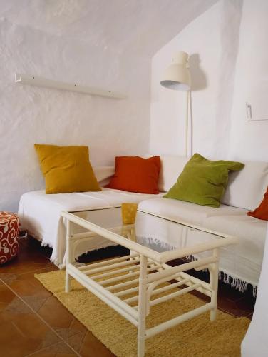 a living room with two beds and a table at Cueva Alfano in Freila