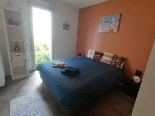 une chambre avec un grand lit avec une couverture bleue dans l'établissement Appartement calme avec jardin dans résidence neuve, à Carcans