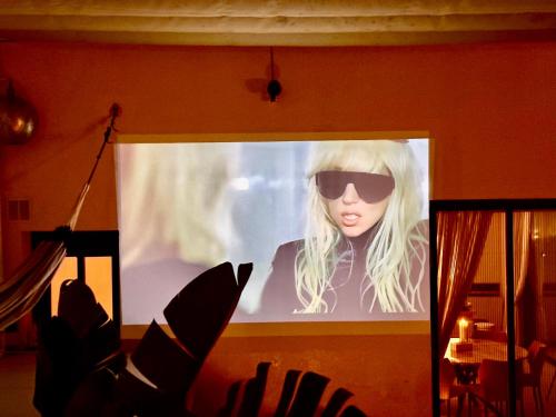 a poster of a woman wearing sunglasses on a screen at Private 250sqm Garden Duplex, Jacuzzi, Cinema, Sea View Escape in Torremolinos