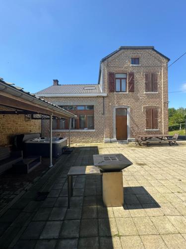 a brick house with a bench in front of it at Gite Familiale La Classe in Modave