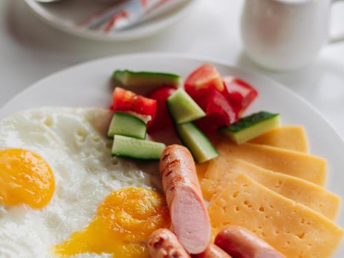 a plate of breakfast food with eggs fruit and vegetables at Kolochava Eco Resort in Kolochava