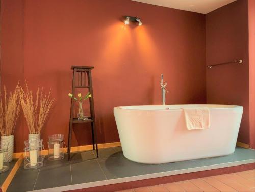 a large bath tub in a bathroom with red walls at Small Luxury Palace Residence in Prague
