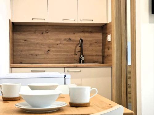 a kitchen with two white bowls on a wooden table at Apartments Miamare in Primošten