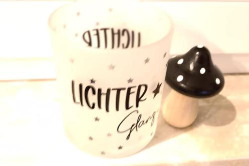 a cup with writing on it next to a figurine at Ferienwohnung Birkenwäldchen in Merchweiler
