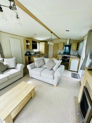 a living room with two white couches and a tv at Holiday Home with Stunning Views in Newquay