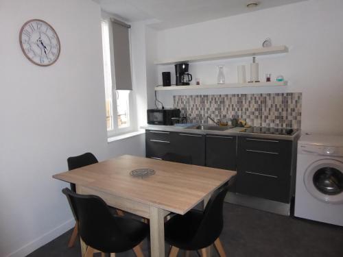 une cuisine avec une table en bois et un lave-linge dans l'établissement T1 Bis - Centre Historique de Narbonne, à Narbonne