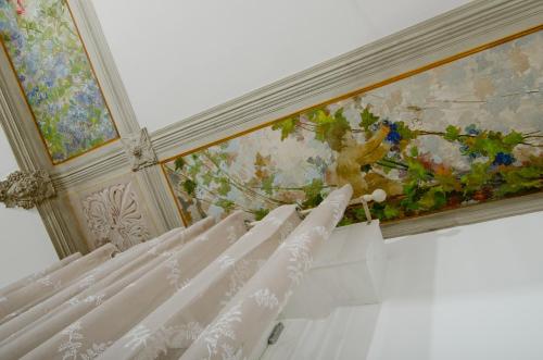 a bedroom with a painting of flowers on the wall at A Casa di Lu Na in Bologna