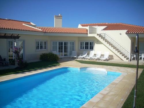 a villa with a swimming pool in front of a house at Luxury 6 Bedroom Oceanfront Vila - Sleeps 22 Guests in Foz do Arelho
