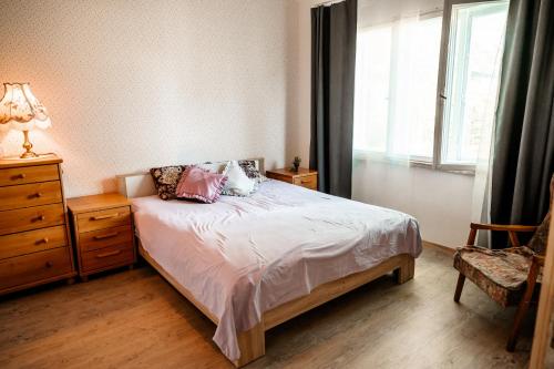 a bedroom with a bed and a dresser and a window at Small Villa Subbi! in Tartu
