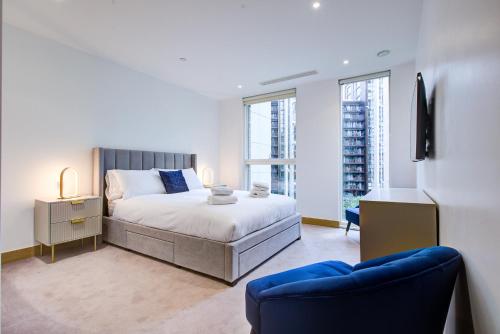 a bedroom with a bed and a blue chair in it at London Paddington Apartment in London