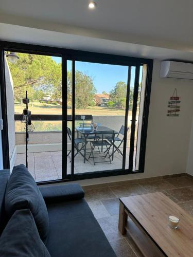 un salon avec un canapé et une table dans l'établissement Les catalanes du golf, à Saint-Cyprien