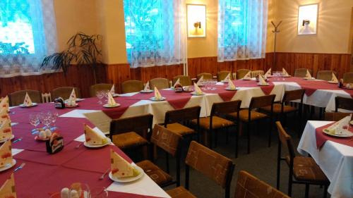 una habitación con mesas y sillas con manteles rojos y blancos en Guest House Pod Lesem Merklín, en Merklín