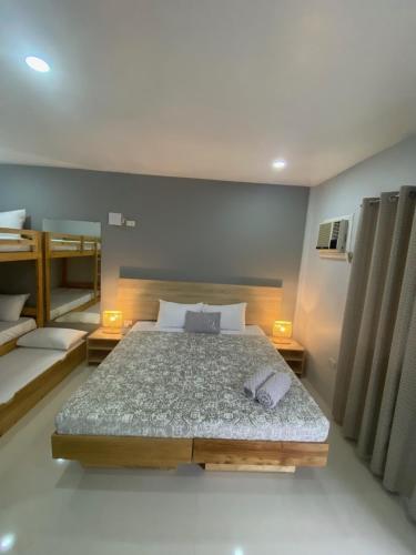 a bedroom with a large bed and two bunk beds at Tropical Stay Accommodations Dao in Tagbilaran City