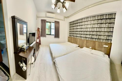 a bedroom with two beds and a mirror at Cian Yuan B&B in Yujing