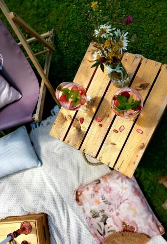 a wooden table with two glasses and flowers on it at LOFT WAPITI in Hutisko