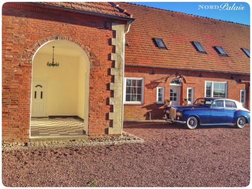 a blue car parked in front of a brick building at Nordpalais vor Sylt in Emmelsbüll-Horsbüll