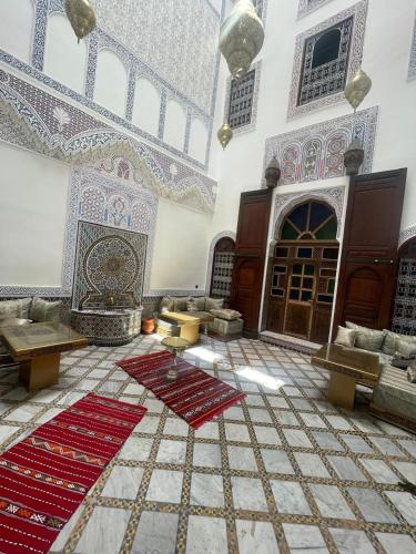 a large room with tables and rugs in a mosque at Riad Taj Fes in Fès