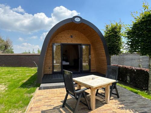 a circular building with a table and chairs in a yard at Woodlodge de luxe 2 persoons in Oorsbeek