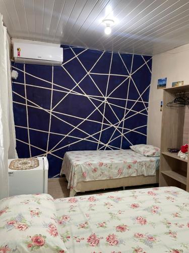 a room with two beds and a blue wall at Estação Noronha in Fernando de Noronha