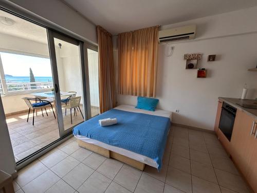 a bedroom with a bed and a balcony with a table at Apartments Mitende in Budva