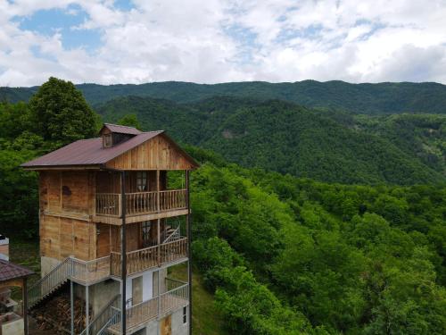 a building in the middle of a valley with trees at Gentry House in Ambrolauri