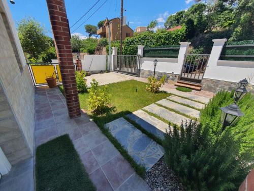 a garden with a brick pillar and grass at Villa Lloret de Mar 6 Personas in Vidreres