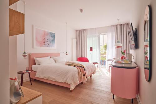 um quarto com uma cama grande e uma cadeira vermelha em New Wave em Norderney