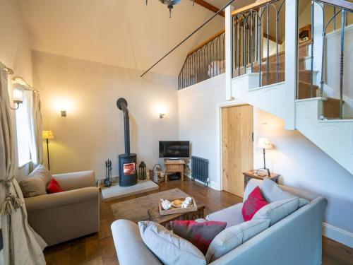 a living room with two couches and a staircase at The Old Chapel. Charming countryside retreat Pass the Keys in Ludlow