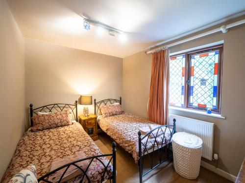two beds in a room with a window at The Old Chapel. Charming countryside retreat Pass the Keys in Ludlow