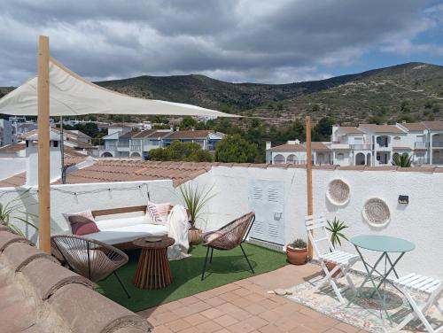 a patio with a couch and chairs and a table at Loft del Sol in Peñíscola