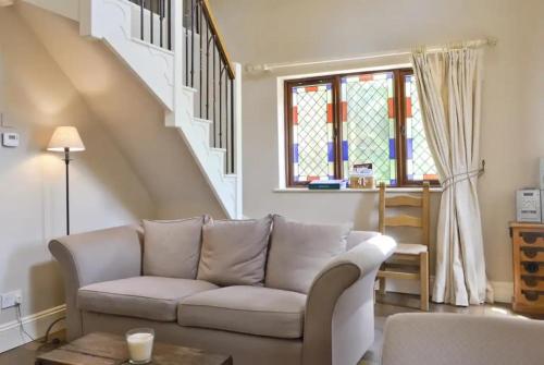 a living room with a couch and a staircase at The Old Chapel. Charming countryside retreat Pass the Keys in Ludlow