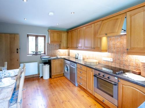 a kitchen with wooden cabinets and wooden floors at The Old Chapel. Charming countryside retreat Pass the Keys in Ludlow