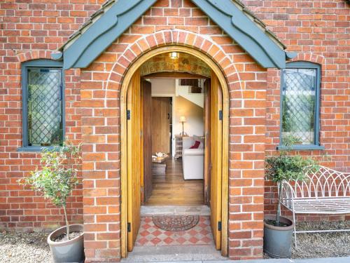 a brick house with an arched entry way at The Old Chapel. Charming countryside retreat Pass the Keys in Ludlow