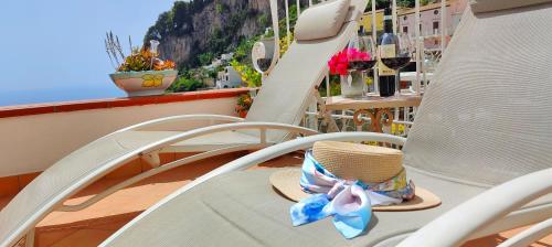 einen Hut auf einem Stuhl auf einem Balkon in der Unterkunft RACHELE HOUSE in Amalfi