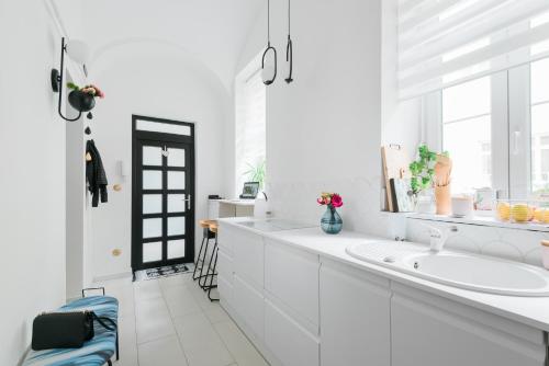 a white bathroom with a sink and a window at S11 Apartman in Debrecen