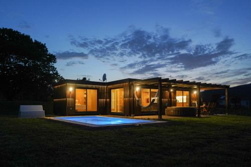 a tiny house with a pool in the yard at night at Quinta da Mó in Terras de Bouro