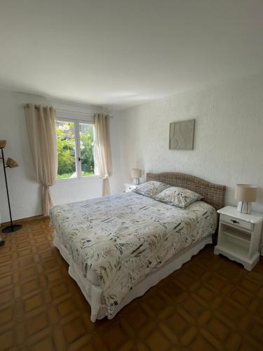 une chambre avec un lit et deux tables et une fenêtre dans l'établissement Bas de villa avec accès piscine près de Nice Cannes Monaco, à Carros