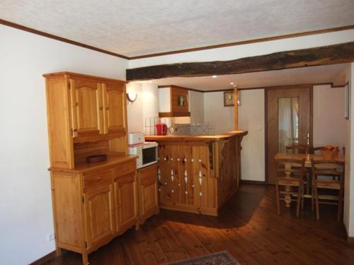 une cuisine avec des placards en bois et une table dans l'établissement Appartement pour 6 pers, parking, animaux admis - FR-1-403-11, à Barèges