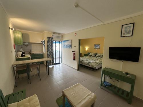 a living room with a bed and a kitchen at Cozy apartment in Praia da Rocha in Portimão