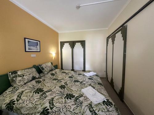 a bedroom with a bed with a comforter on it at Cozy apartment in Praia da Rocha in Portimão