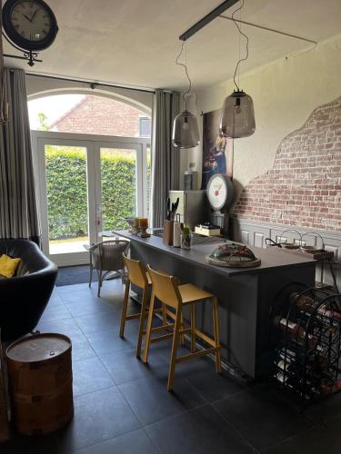 a kitchen with a table and chairs and a clock at Vakantiewoning Fruitschuur de Morel in Venlo