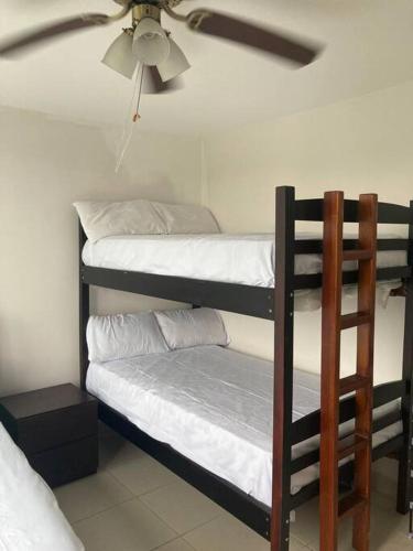 two bunk beds in a room with a ceiling fan at Suite 6 per Tonsupa Edf Tritón in Tonsupa