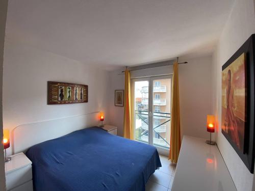 une chambre avec un lit bleu et une fenêtre dans l'établissement Nice Magnan 2P-Piscine, Clim, Parking, à Nice